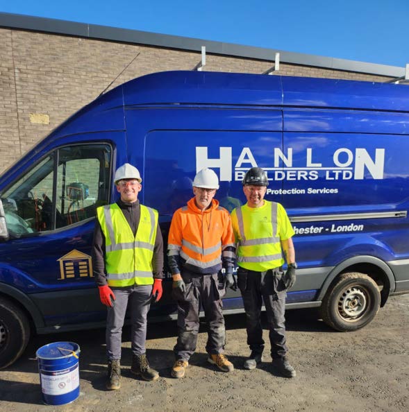 3 builders wearing safety workwear standing in front of a blue van with Hanlon Builders branding